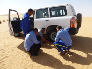 Group of four people carrying out driver training in Qatar desert in 4x4